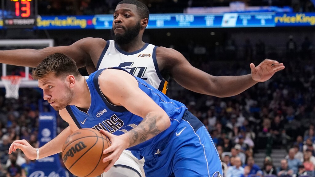 Dallas Mavericks guard Luka Doncic, front, drives past Utah Jazz forward Eric Paschall (0) during the second half of an NBA basketball game in Dallas, Sunday, March 27, 2022. (AP Photo/LM Otero)