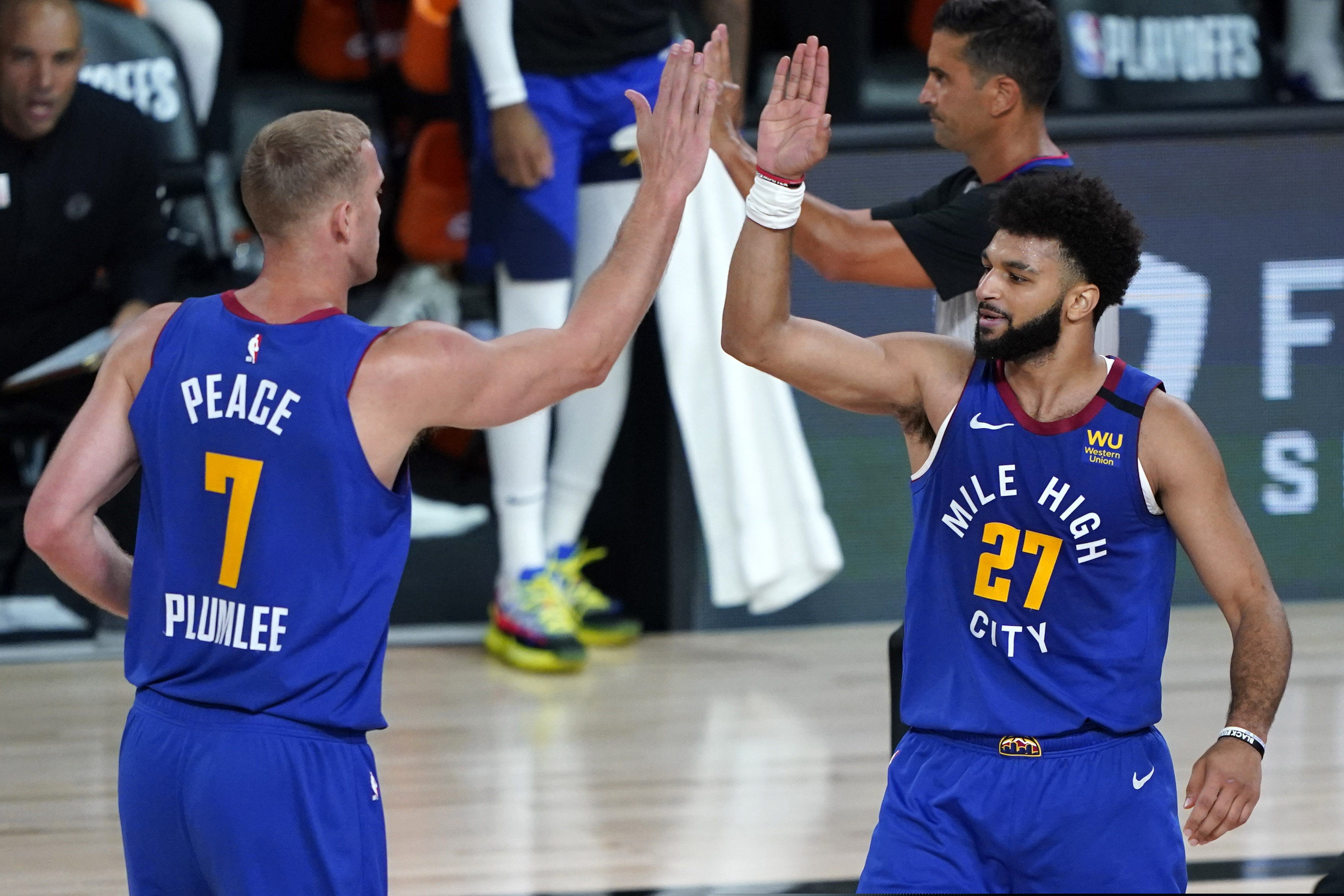 Denver Nuggets' Jamal Murray (27) celebrates with Mason Plumlee (7) during the first half of an NBA basketball first round playoff game against the Utah Jazz Sunday, Aug. 30, 2020, in Lake Buena Vista, Fla. (AP Photo/Ashley Landis)