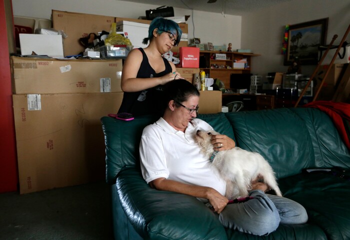 (Lynne Sladky | The Associated Press) In this Monday, March 13, 2017 photo, Theo Ramos, left, does his mother Lori's hair at their home in Homestead, Fla. Lori believes Theo’s gender dysphoria is a component of the overall depression, not the root cause. Now, Theo said, he attributes about 15 percent of his anxiety and depression to gender issues; it used to be 95 percent.