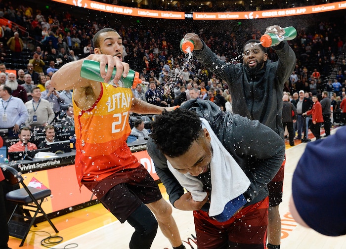 (Francisco Kjolseth  |  The Salt Lake Tribune)  Utah Jazz center Rudy Gobert (27) and Utah Jazz forward Royce O'Neale (23) spray Utah Jazz guard Donovan Mitchell (45) with water as he does an interview celebrating his career high game of 46 points for the second time as the Utah Jazz host the Denver Nuggets in their NBA game at Vivint Smart Home Arena Tuesday, April 9, 2019, in Salt Lake City.