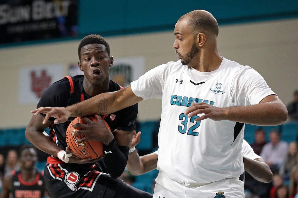 Utah center Lahat Thioune, left, carries the ball while Coastal Carolina center Levi Cook (32) defends during the first half of an NCAA college basketball game at the Myrtle Beach Invitational in Conway, S.C., Thursday, Nov. 21, 2019. (AP Photo/Gerry Broome)