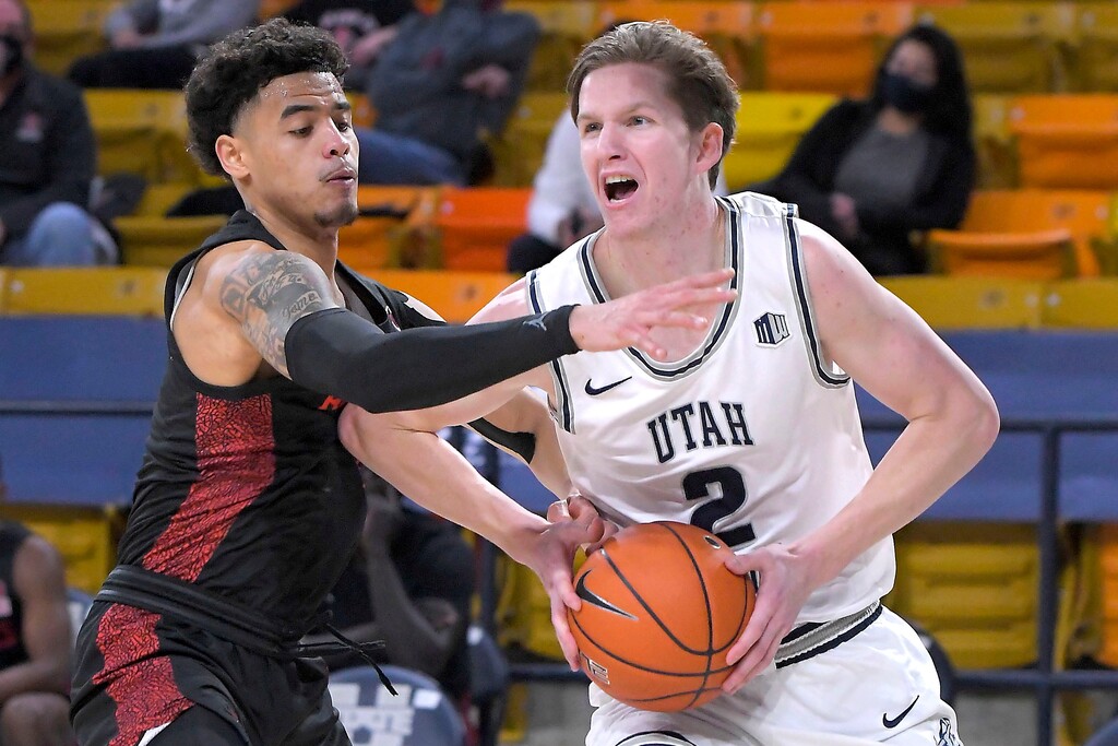 Utah State guard Sean Bairstow (2) drives to the basket as San Diego State guard Trey Pulliam defends during the first half of an NCAA college basketball game Thursday, Jan. 14, 2021, in Logan, Utah. (Eli Lucero/The Herald Journal via AP, Pool)