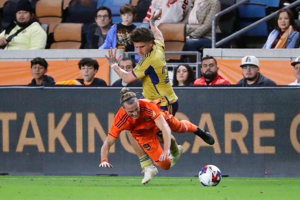 Houston Dynamo midfielder Griffin Dorsey, front, goes down as he tries to keep the ball from Real Salt Lake midfielder Diego Luna, back, during the first half of an MLS playoff soccer match Saturday, Nov. 11, 2023, in Houston. (AP Photo/Michael Wyke)