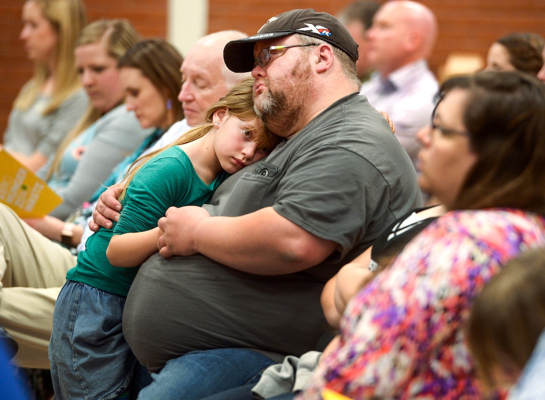 (Leah Hogsten  |  The Salt Lake Tribune) "It can help us out in those tight situations," said R.J. Spencer, center, and his wife, Rebekah, right, of the new food pantry at their children's school, Tuesday, March 13, 2018. R.J. Spencer is the caretaker of his daughter Ailie, 8, who he hugs and her two siblings while his wife Rebekah is a teacher at Granger High School. "It gets tight for money," said Spencer of their one income family. "We just have to buckle down." Smiths Food & Drug is helping to open a food pantry at David Gourley Elementary School in Kearns, where 80 percent of the 646 students qualify for free or reduced lunches. 