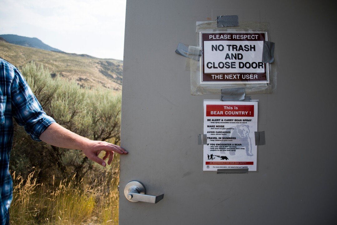 (Eli Imadali  |  Bozeman Daily Chronicle) A user opens the bathroom door at McConnel River Access point in the Gallatin National Forest along the Yellowstone River, just outside of Yellowstone National Park. The price of pumping waste out of United States Forest Service bathrooms has increased by over 100 percent over the last five years.