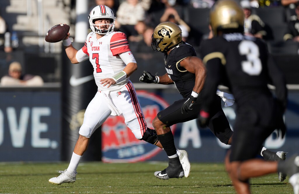 (David Zalubowski | AP) Utah quarterback Cameron Rising, left, looks to pass the ball as Colorado linebacker Marvin Ham II pursues in the first half of a game Nov. 26, 2022, in Boulder, Colo. Colorado appears ready to leave the Pac-12 for the Big 12, according to multiple reports.