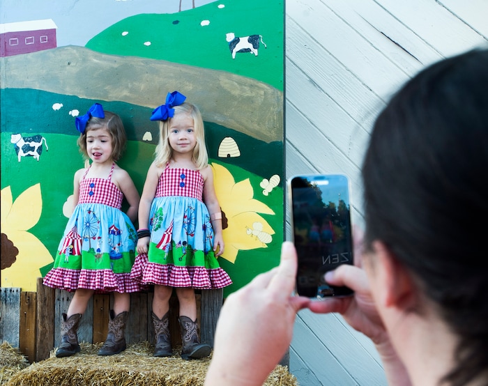 (Rick Egan  |  The Salt Lake Tribune)  Bethany Cutler takes a photo of her 5-year-old twins, Sophie and Charolette,in their Sate Fair outfits, at the Utah State Fair,  Monday, September 11, 2017.



