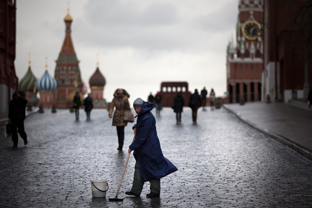 (AP Photo/Alexander Zemlianichenko) A street worker cleans paving stones in Red Square with St. Basil's Cathedral, left, Lenin Mausoleum,  center, and the Spasskaya Tower, right, in Moscow, Russia, Tuesday, Dec. 22, 2015.