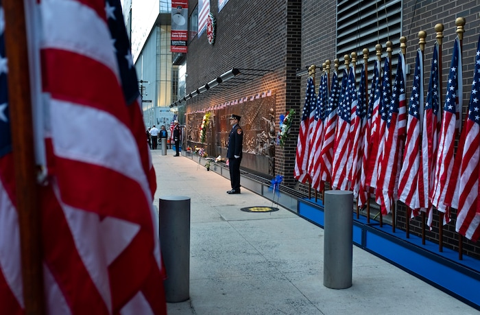 (Craig Ruttle | AP Photo) New York City firefighters stand at attention in front of a memorial on the side of a firehouse adjacent to One World Trade Center and the 9/11 Memorial site during ceremonies commemorating the 18th anniversary of the 9/11 terrorist attacks in New York on Wednesday, Sept. 11, 2019.