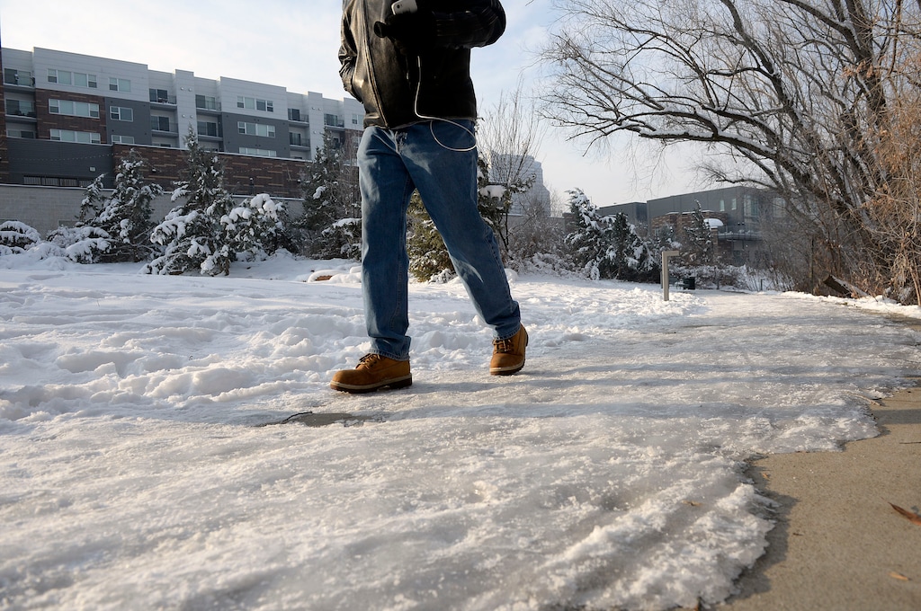 Al Hartmann | The Salt Lake Tribune
Person with vibram boots treads carefully along the icy sidewalk through Hidden Hollow Natural Area Friday Dec. 30. The snow has apparently not been removed since the major storm nearly a week ago making walking dangerous.
When it snows, Salt Lake City Code 14.20.070 requires that you:
Clear snow and ice from City sidewalks adjacent to your property within twenty-four (24) hours after the end of the storm.
Make a minimum 42-inch wide path, or if the sidewalk is less than 42 inches wide, clear the full width.
Clear the full length of the sidewalk, including from corners and curb ramps.
Ice must be removed to bare pavement, or made as level as possible and treated with ice melt, sand or similar material.
Do not move snow into the street or onto other sidewalks.