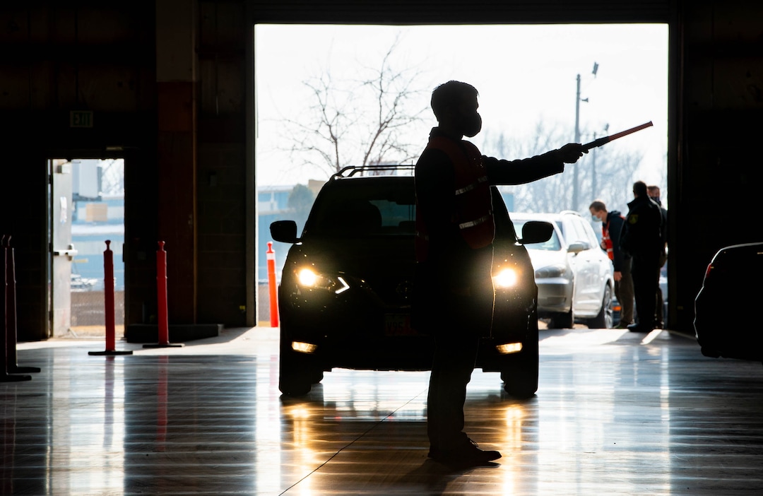 (Francisco Kjolseth  | The Salt Lake Tribune) Eric Taylor with Davis County Environmental Services, lends a hand directing traffic as the Davis County School District begins COVID-19 vaccinations for its teachers at the Davis County Legacy Center in Farmington on Tuesday, Jan. 12, 2021.