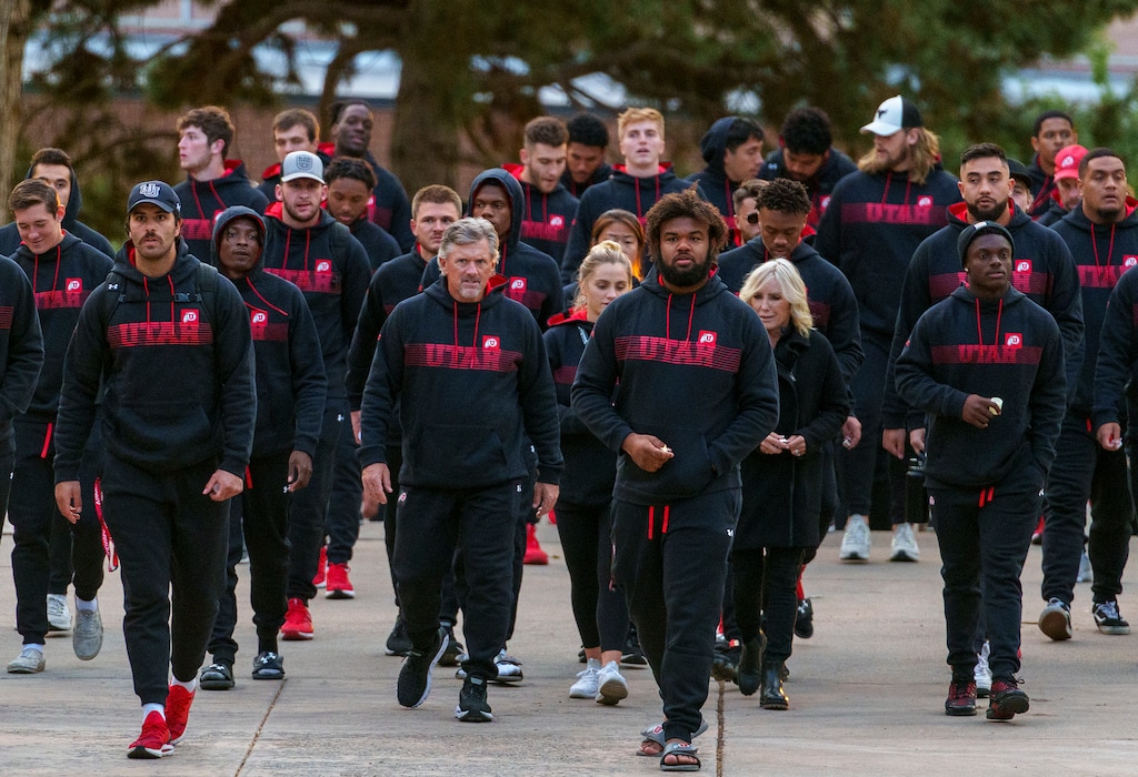 (Leah Hogsten | The Salt Lake Tribune)  The University of Utah football team walks together on campus to the A Ray Olpin Student Union southwest lawn to remember and honor the life of fellow student-athlete Aaron Lowe during a candlelight vigil, Sept. 29, 2021.