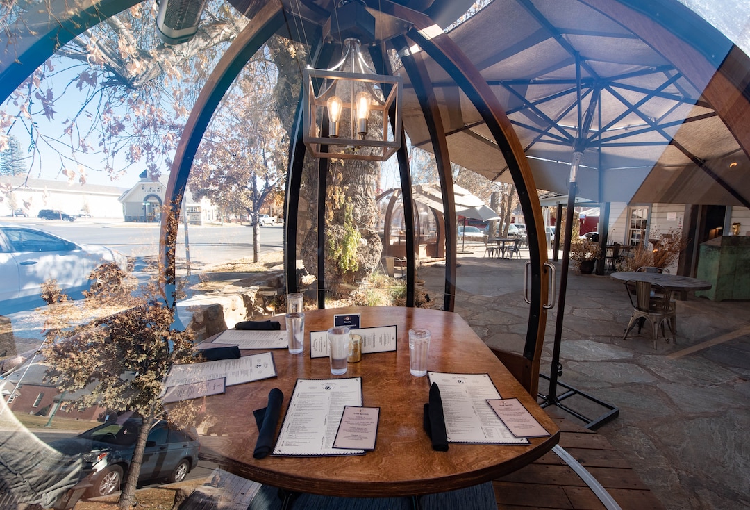 (Francisco Kjolseth  |  The Salt Lake Tribune) The dome-like Alpenglobes that allow diners to eat inside a warm environment, while also being separated from others have been added at Cafe Galleria in Midway as a table is set on Thursday, Nov. 5, 2020. The owners were trying to find a way to use their outdoor patio in the winter, teaming up with Insight Exhibit, a Salt Lake City corporate event company that was looking for a way to make money while large gatherings have been cancelled.