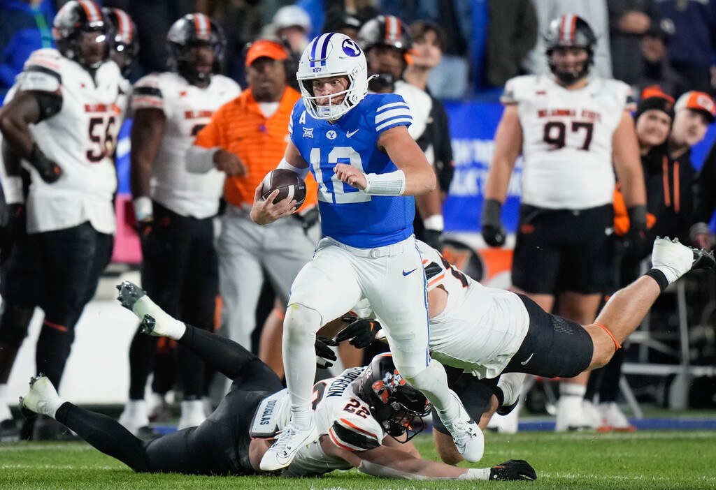 (Francisco Kjolseth | The Salt Lake Tribune) Brigham Young Cougars quarterback Jake Retzlaff (12) eludes the Oklahoma State Cowboys defense in the final seconds of the game as he sets himself up for a game winning pass in Provo on Friday, Oct. 18, 2024.