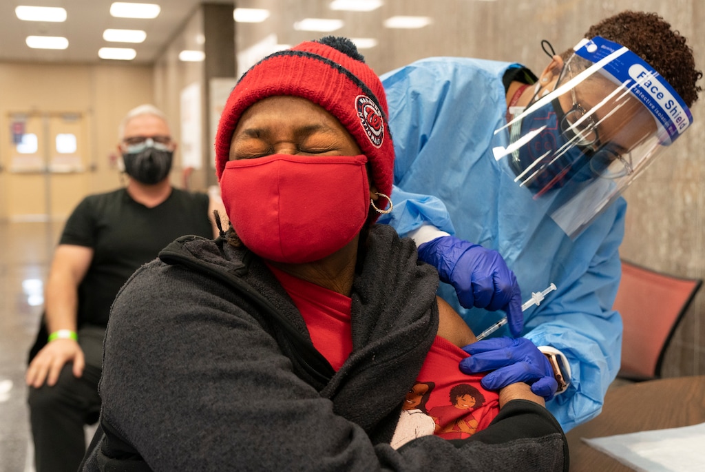 In this Thursday, Feb. 11, 2021, photo Jorie Winbish, 56, of Washington, reacts as she receives her second dose of the COVID-19 vaccine at a clinic at Howard University, in Washington. "I feel so lucky to have number two in my arm," says Winbish. (AP Photo/Jacquelyn Martin)