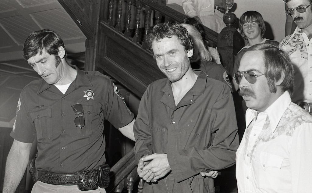 In this 1977 photo serial killer Ted Bundy, center, is escorted out of court in Pitkin County, Colo. The Glenwood Springs Post-Independent discovered the 40-year-old photo of Bundy, along with others, that had been locked in an old safe in the newsroom, which a local locksmith volunteered to open. The photos show Bundy in custody in 1977, the year he escaped from local law enforcement twice while awaiting a murder trial. (Glenwood Springs Post Independent via AP)