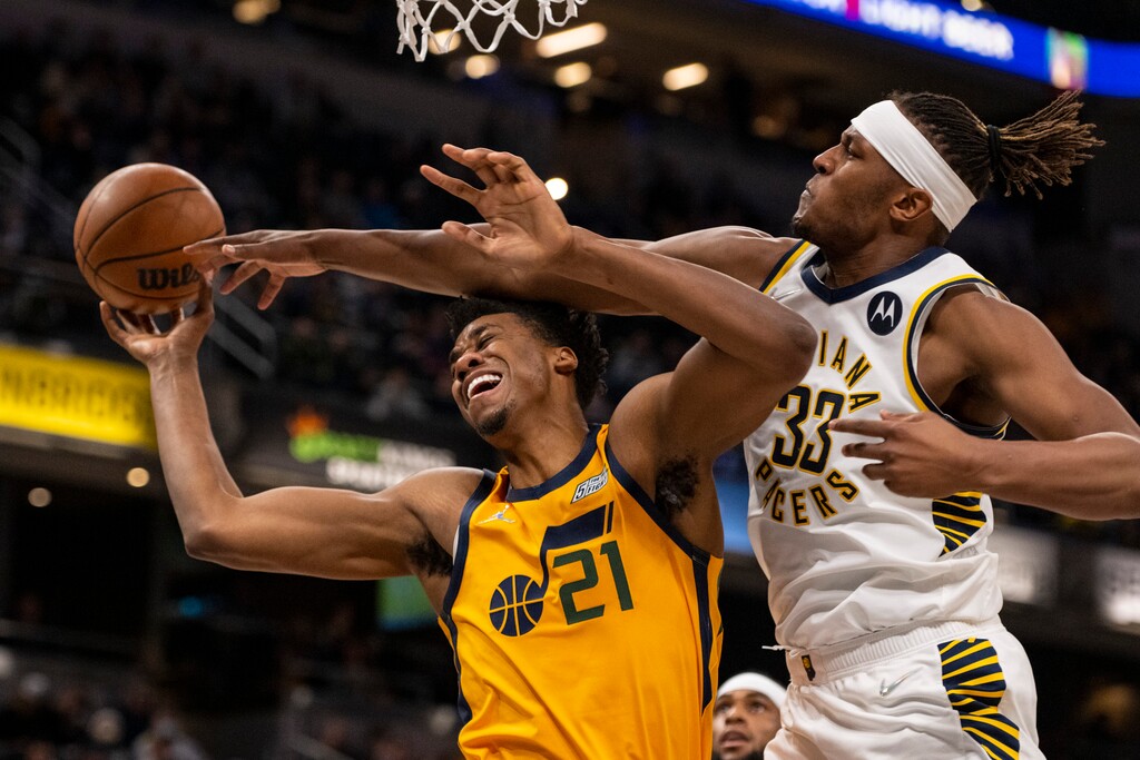 Indiana Pacers center Myles Turner (33) fouls Utah Jazz center Hassan Whiteside (21) who was attempting to score during the second half of an NBA basketball game in Indianapolis, Saturday, Jan. 8, 2022. (AP Photo/Doug McSchooler)