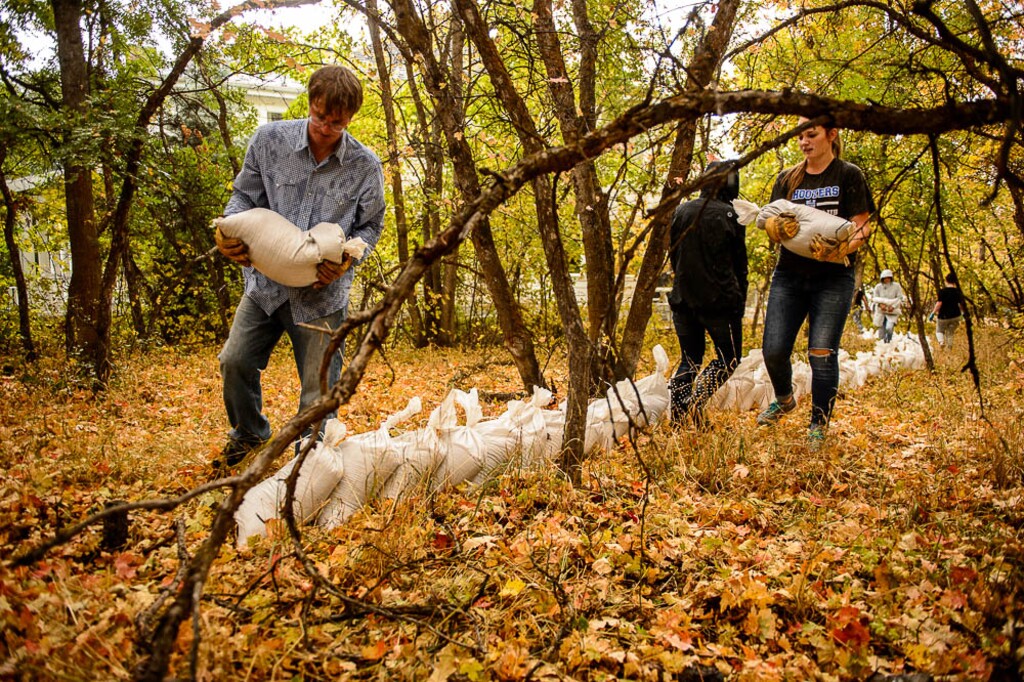 (Trent Nelson | The Salt Lake Tribune) Bret Sorensen is helped by familiy and friends, laying out sandbags behind his home as the rain begins to fall in Woodland Hills, Tuesday Oct. 2, 2018.