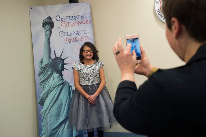 (Scott Sommerdorf   |  The Salt Lake Tribune)   Lachlan Murray smiles as her mother Rose makes a photo of her prior to a ceremony in recognition of children who have obtained citizenship through their parents, Thursday, December 28, 2017. Some children were adopted by U.S. citizen parents; others derived citizenship when their immigrant parents became naturalized citizens.