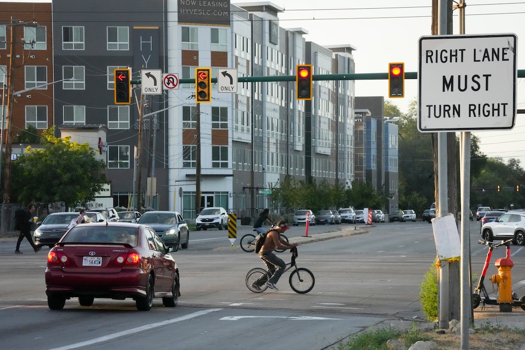 (Bethany Baker  |  The Salt Lake Tribune) People bike and walk across Redwood Road along North Temple in Salt Lake City on Tuesday, July 22, 2025.