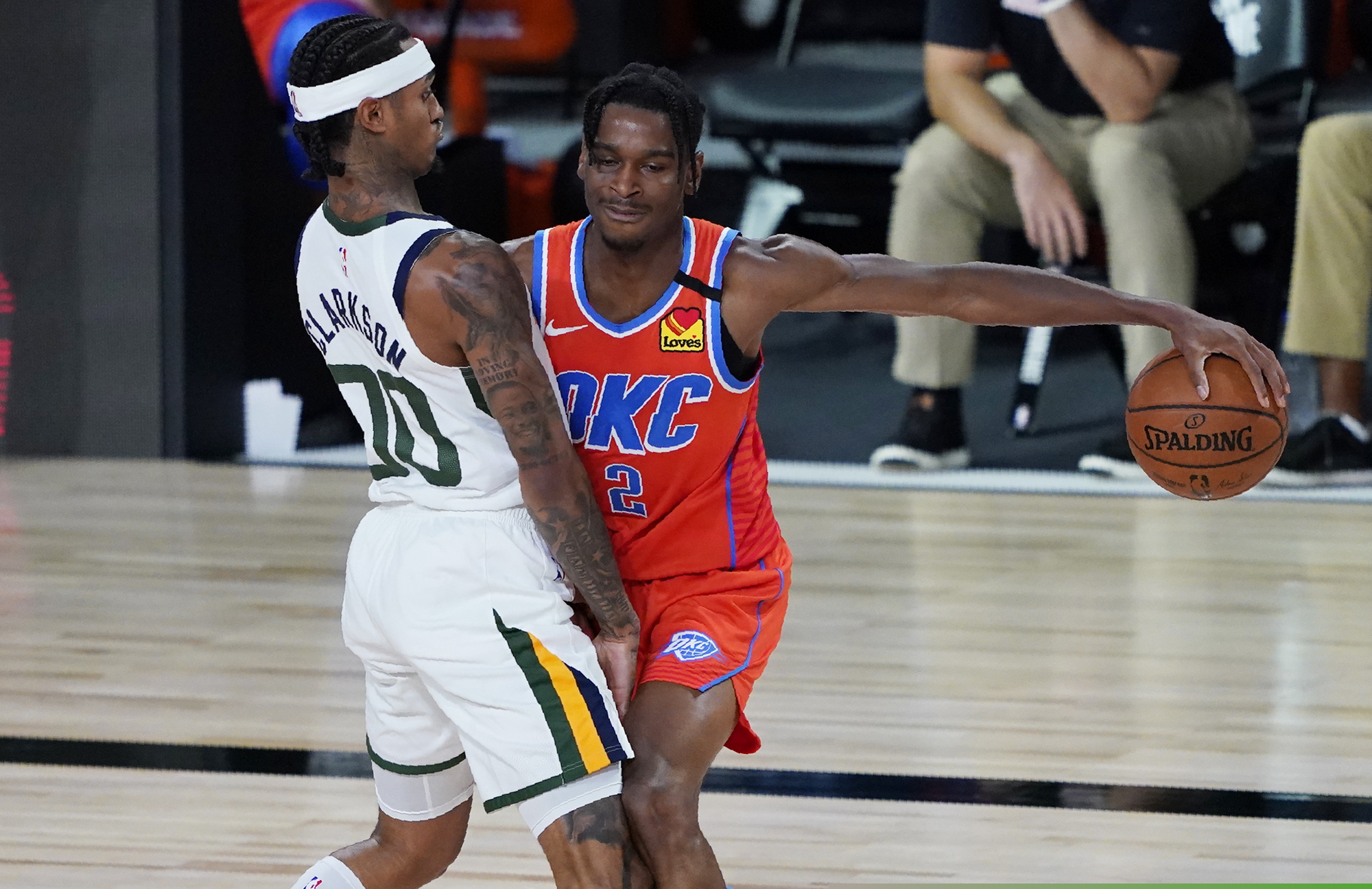 Oklahoma City Thunder's Shai Gilgeous-Alexander (2) drives into Utah Jazz's Jordan Clarkson (00) during the second half of an NBA basketball game Saturday, Aug. 1, 2020, in Lake Buena Vista, Fla. (AP Photo/Ashley Landis, Pool)
