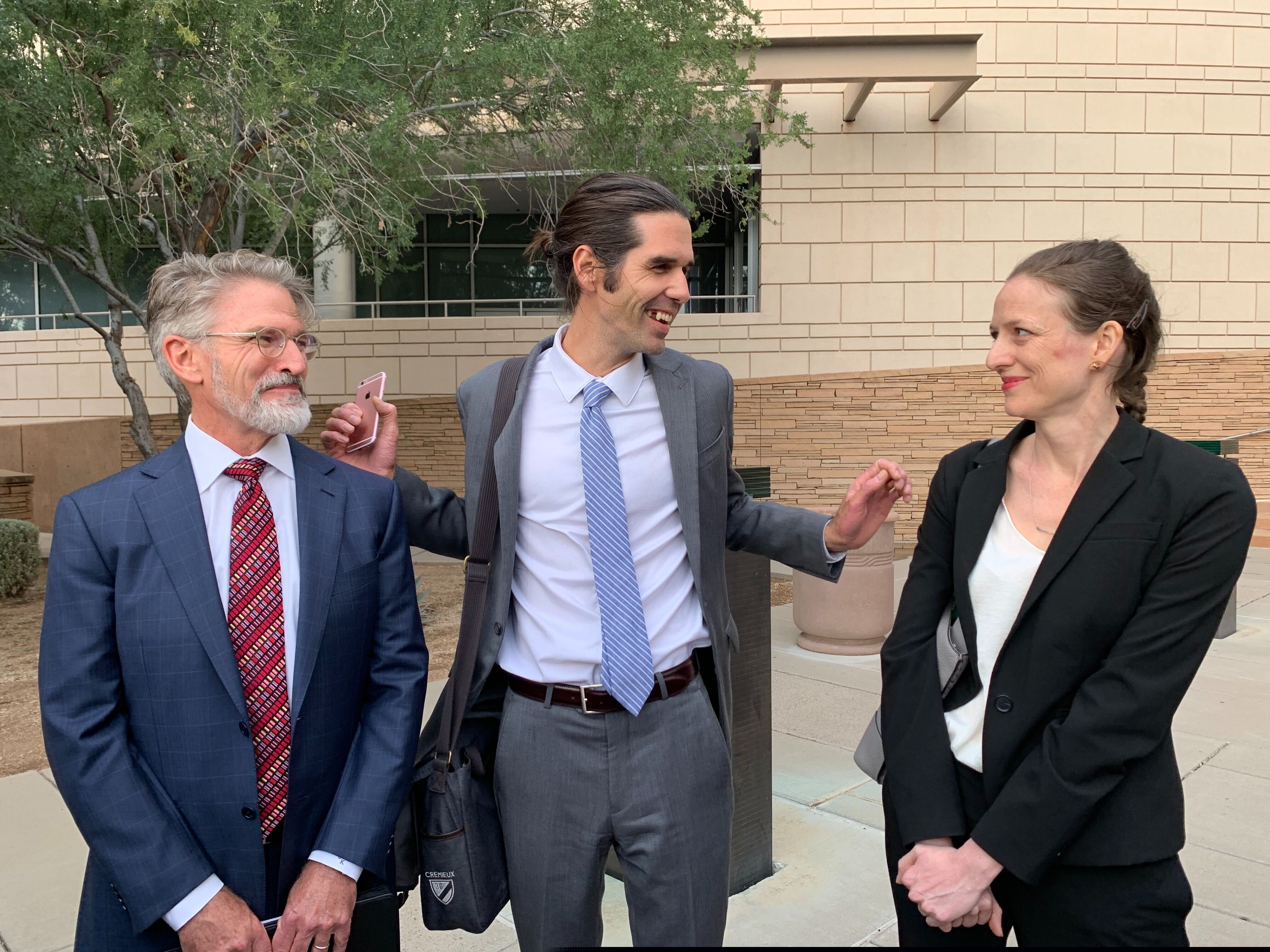 (Astrid Galvan | AP) Scott Warren, center, of Ajo, Ariz., celebrates with his attorneys Amy Knight, right, and Greg Kuykendall outside court in Tucson, Ariz. on Wednesday, Nov. 20, 2019, after being acquitted of two counts of harboring in a case that garnered international attention. Prosecutors said Warren illegally helped two migrants avoid authorities. He said he was fulfilling his humanitarian duties by helping two injured men.