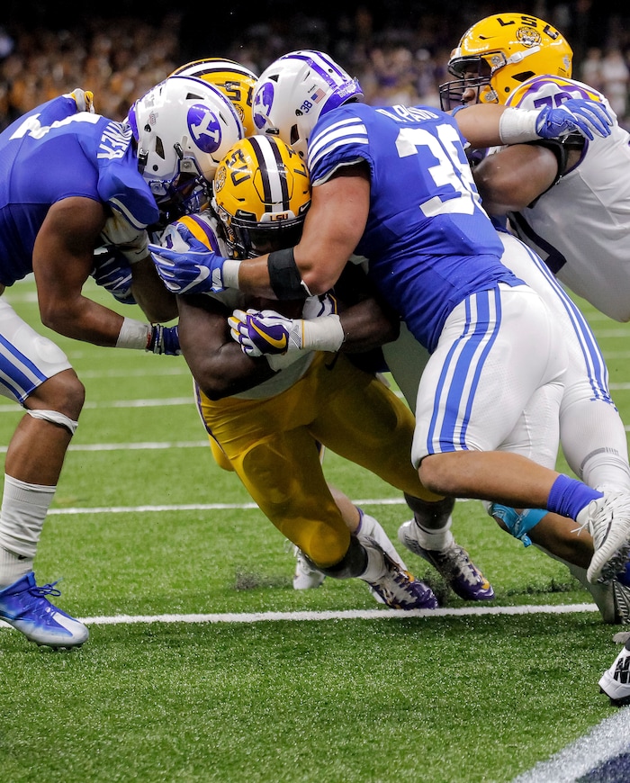 LSU running back Darrel Williams (28) scores against BYU defenders Butch Pau'u, right, and Troy Warner, left, during the second half of an NCAA college football game in New Orleans, Saturday, Sept. 2, 2017. (AP Photo/Scott Threlkeld)