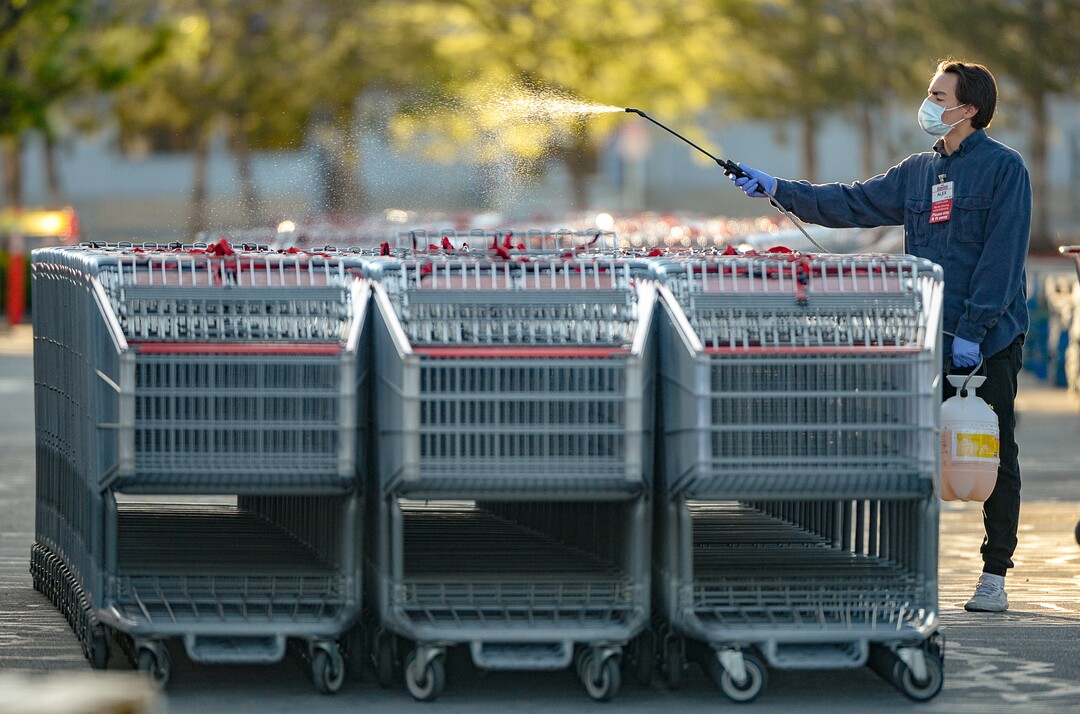 (Francisco Kjolseth  |  The Salt Lake Tribune) Costco staff sanitize shopping carts as they begin implementing a policy on Monday, May 4, 2020, that everyone in the store, including shoppers, have to wear a mask.