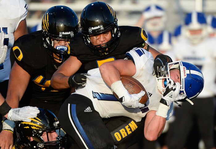 (Francisco Kjolseth  |  The Salt Lake Tribune)  Bingham's Braedon Wissler has his helmet twisted as the Orem defense roughs him up in Orem,  Thursday, Aug. 16, 2018.
