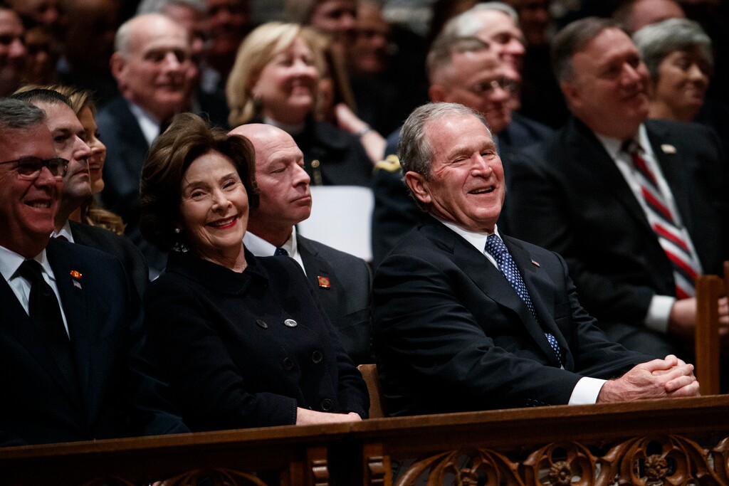 Jeb Bush, Laura Bush, and former President George W. Bush share a laugh as a story is told about former President George H.W. Bush during a State Funeral at the National Cathedral, Wednesday, Dec. 5, 2018, in Washington. (AP Photo/Evan Vucci)