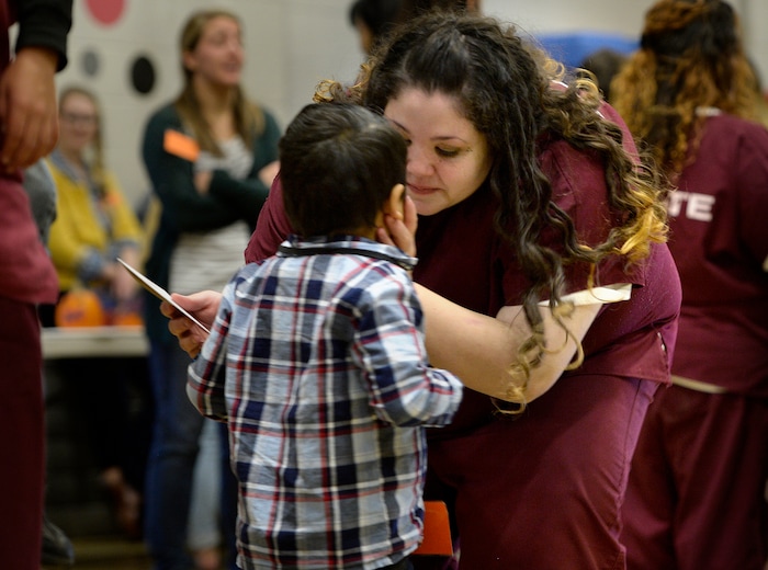 (Scott Sommerdorf   |  The Salt Lake Tribune)   Elicia Chavez cradles her son Damiano's face in her hand as they visit in the prison gymnasium during "Kids Day" at the Utah State Prison, Saturday, October 7, 2017. 