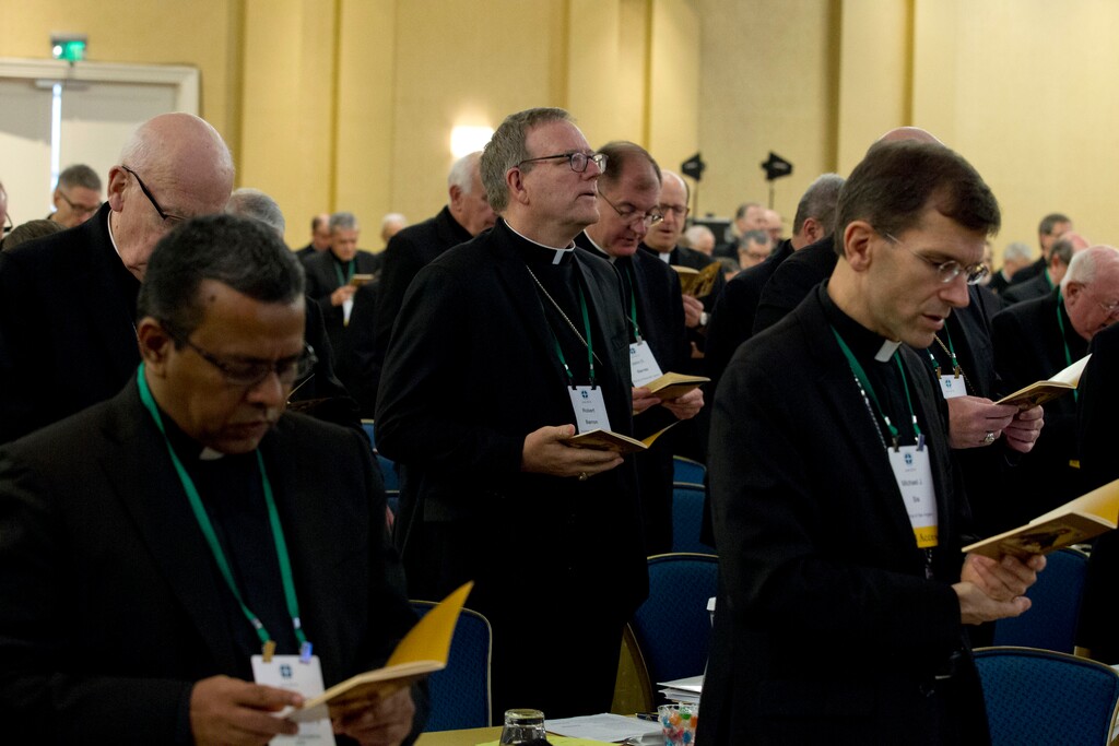 (AP Photo/Jose Luis Magana) Auxiliary Bishop Robert Barron of Los Angeles, center, along with other bishops, participates in a morning prayer, during the United States Conference of Catholic Bishops (USCCB), 2019 Spring meetings in Baltimore, Tuesday, Jun 11, 2019.