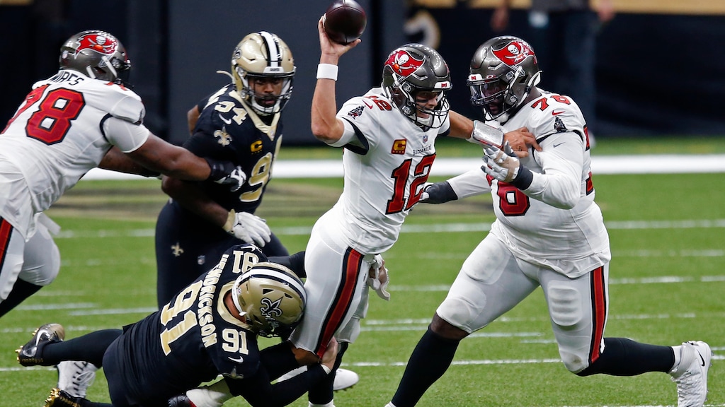 Tampa Bay Buccaneers quarterback Tom Brady (12) tries to throw as he is brought down by New Orleans Saints defensive end Trey Hendrickson (91) in the first half of an NFL football game in New Orleans, Sunday, Sept. 13, 2020. He was called for intentional grounding on the play. (AP Photo/Butch Dill)