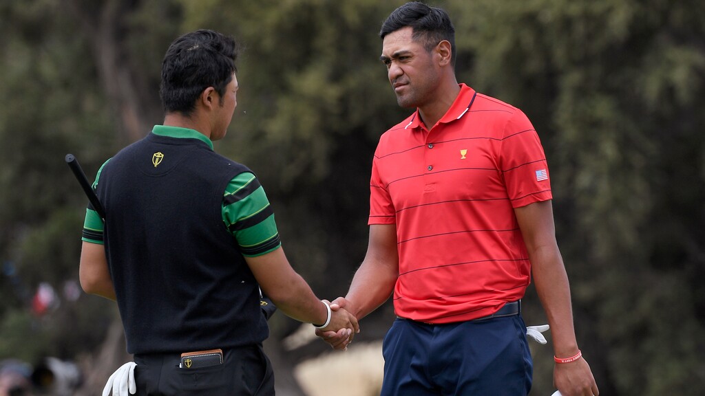 International team player Hideki Matsuyama of Japan, left, and U.S. team player Tony Finau shake hands after tying their singles match during the President's Cup golf tournament at Royal Melbourne Golf Club in Melbourne, Sunday, Dec. 15, 2019. (AP Photo/Andy Brownbill)