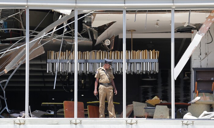 A Sri Lankan Police officer inspects a blast spot at the Shangri-la hotel in Colombo, Sri Lanka, Sunday, April 21, 2019. More than hundred people were killed and hundreds more hospitalized from injuries in near simultaneous blasts that rocked three churches and three luxury hotels in Sri Lanka on Easter Sunday, a security official told The Associated Press, in the biggest violence in the South Asian country since its civil war ended a decade ago.(AP Photo/Eranga Jayawardena)