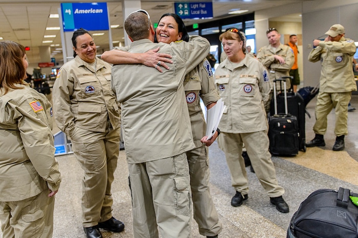 (Trent Nelson | The Salt Lake Tribune) Terry Begay and Ian Hess embrace as members of Utah's DMAT-1 (Disaster Medical Assistance Team) meet at the Salt Lake City Airport en route to Texas, Tuesday August 29, 2017. 36 members of the team are headed to the Houston area to help with the fallout of Hurricane Harvey.