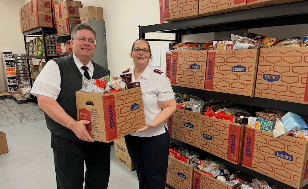 (Bob and Karen Schmig) Majors Bob and Karen Schmig, officers over the Salvation Army outpost in Washington City, hold a food box to be distributed to low-income families.