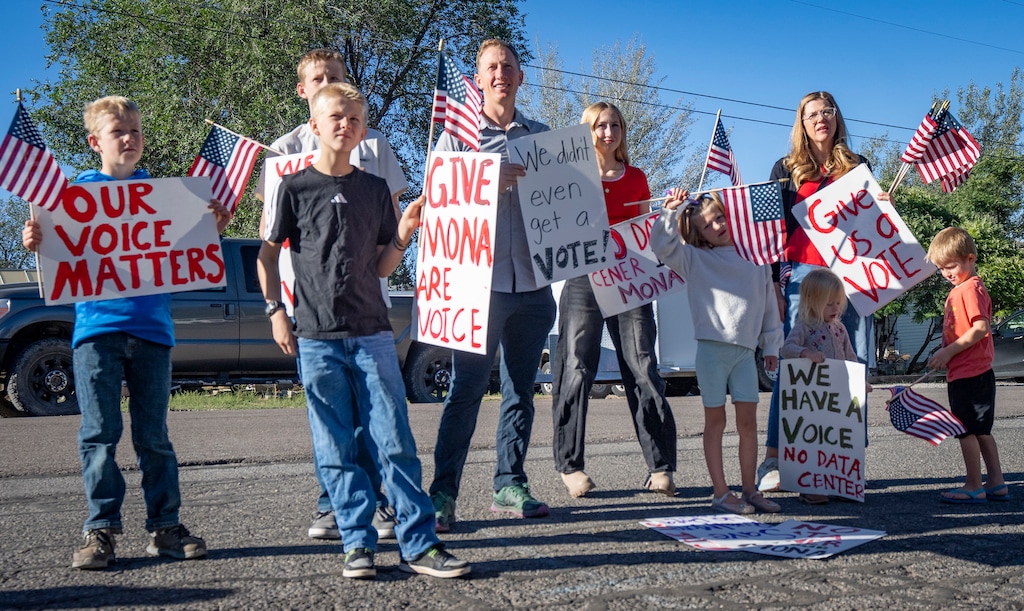 (Rick Egan | The Salt Lake Tribune) The Cooper family hold signs as they gather for a rally opposing a data center planned near Mona, on Tuesday, Sept. 8, 2026.
