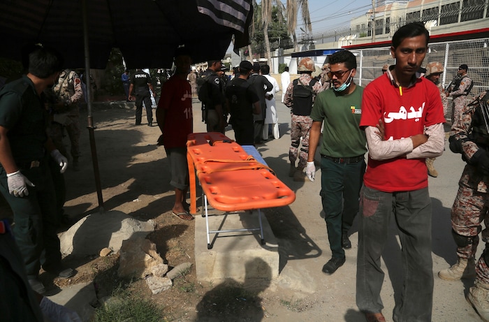 Volunteers wait outside the Chinese Consulate after an attack in Karachi, Pakistan, Friday, Nov. 23, 2018. Pakistani police say gunmen have stormed the Chinese Consulate in the country's southern port city of Karachi, triggering an intense shootout. (AP Photo/Shakil Adil)