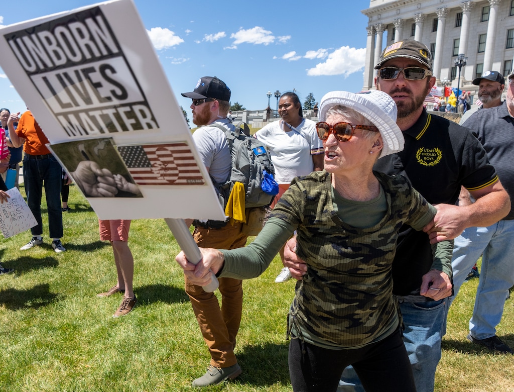 (Rick Egan | The Salt Lake Tribune)  An angry Pro-life advocate us pulled back by a Utah Proud Boy as she attempts to provoke counter protesters as Abortion Free Utah and other groups gather at the Capitol to celebrate the end of Roe v. Wade, on Saturday, July 2, 2022.