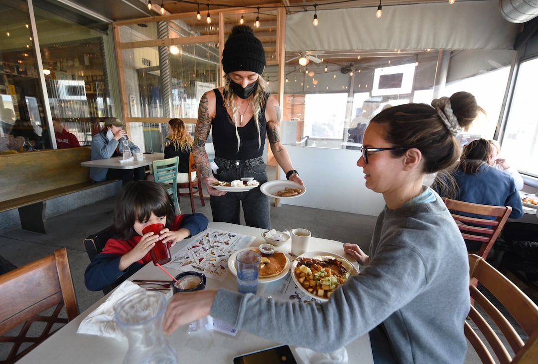 (Francisco Kjolseth  | The Salt Lake Tribune) Brittany Ostrowski brings breakfast to Laura Miller and her son Arjun Nair, 4, as they enjoy the patio area at Blue Plate Diner on Friday, March 12, 2021. The popular eatery will be closing on May 4, after 20 years in business. A new development is going in on the corner that is forcing it to shut down.