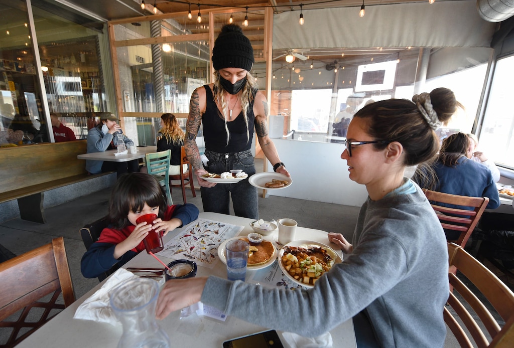 (Francisco Kjolseth | The Salt Lake Tribune) Brittany Ostrowski brings breakfast to Laura Miller and her son Arjun Nair, 4, as they enjoy the patio area at Blue Plate Diner on Friday, March 12, 2021. According to a new report released Tuesday, April 5, 2021, from the Utah Women and Leadership Project, women working in food services in the Beehive State have seen one of the largest decreases in income and biggest increases in hours worked during the COVID-19 pandemic.