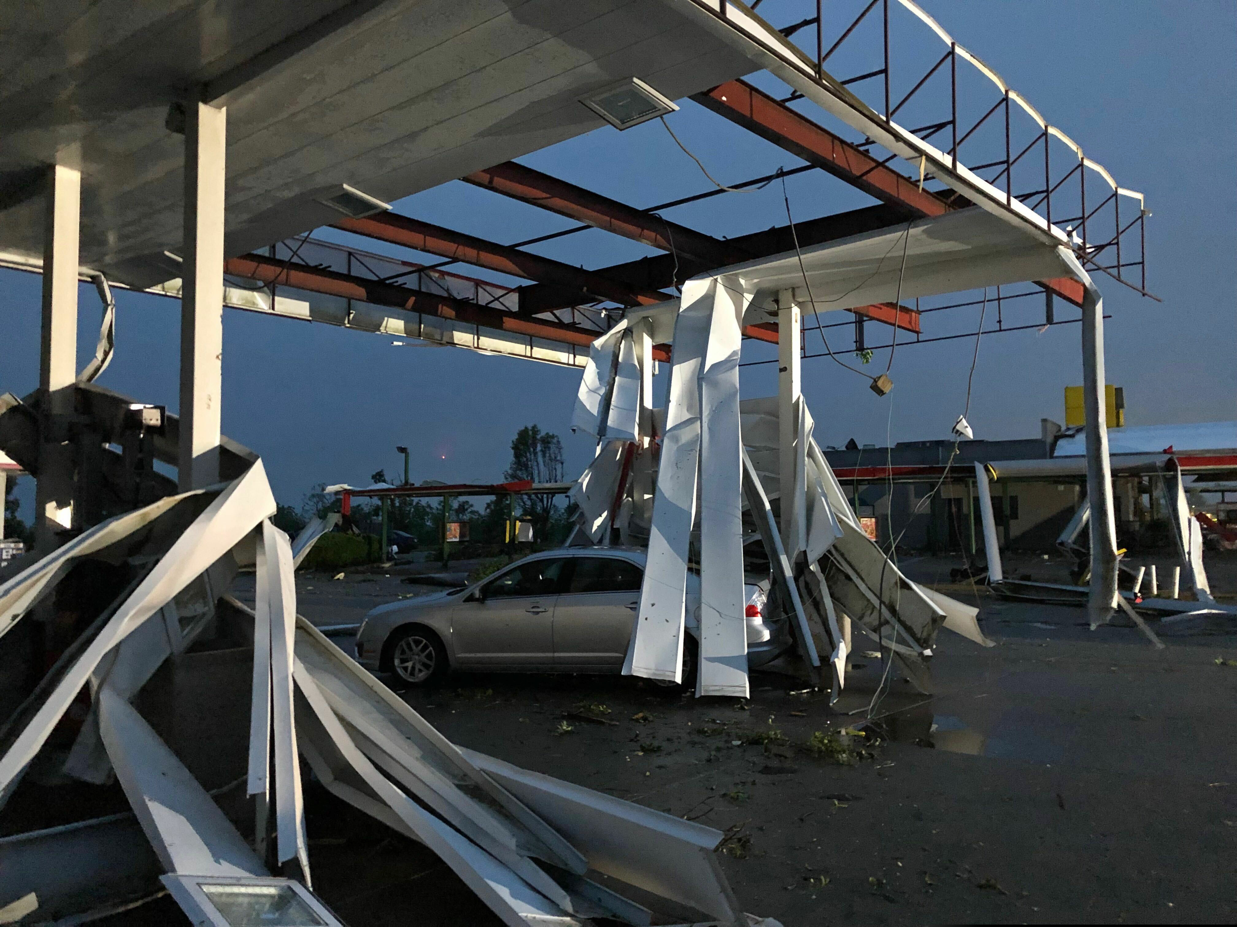 (David A. Lieb | AP) A car is trapped under the fallen metal roof of the Break Time gas station and convenience store in tornado-hit Jefferson City, MO., Thursday, May 23, 2019. The National Weather Service has confirmed a large and destructive tornado has touched down in Missouri's state capital, causing heavy damage and trapping multiple people in the wreckage of their homes.