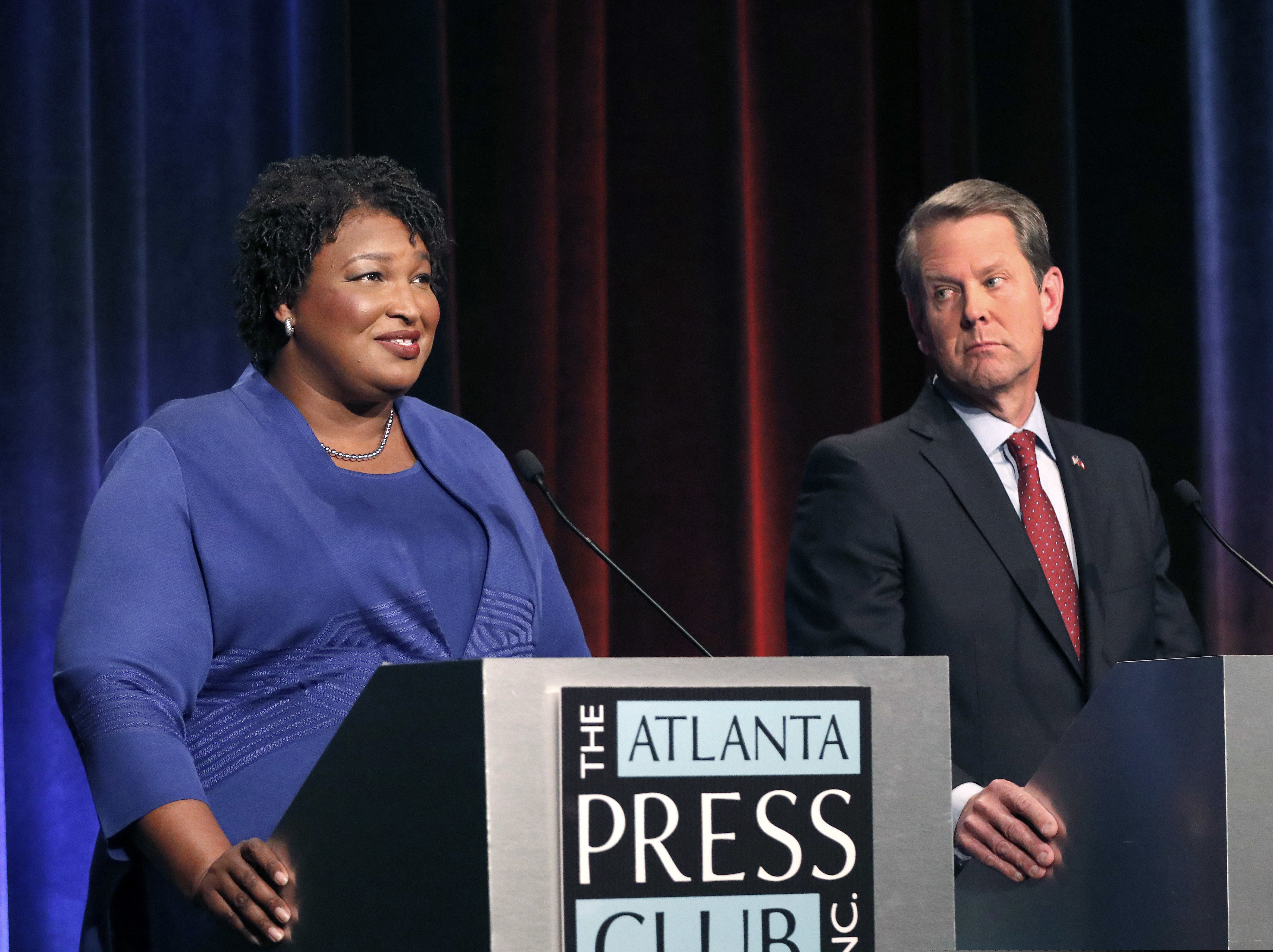 FILE - In this Tuesday, Oct. 23, 2018 file photo, Democratic gubernatorial candidate for Georgia Stacey Abrams, left, speaks as her Republican opponent Secretary of State Brian Kemp looks on during a debate in Atlanta. A federal judge says Georgia election officials must stop rejecting absentee ballots and absentee ballot applications because of a mismatched signature without first giving voters a chance to fix the problem. U.S. District Judge Leigh May on Wednesday, Oct. 24, 2018 ordered the secretary of state's office to instruct county election officials to stop the practice for the November midterm elections. She outlined a procedure to allow voters to resolve alleged signature discrepancies.(AP Photo/John Bazemore, Pool, File)