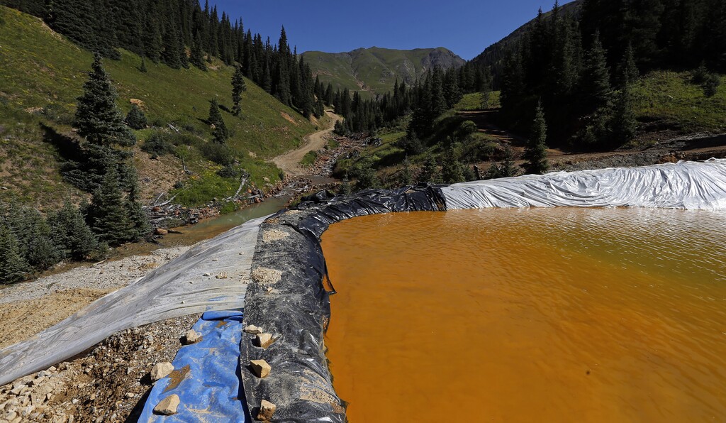 (AP Photo/Brennan Linsley) Water flows through a series of sediment retention ponds built to reduce heavy metal and chemical contaminants from the Gold King Mine wastewater accident, in the spillway about 1/4 mile downstream from the mine, outside Silverton, Colo., Friday, Aug. 14, 2015. Officials have said that federal contractors accidentally released more than 3 million gallons of wastewater laden with heavy metals last week at the Gold King Mine near Silverton. The pollution flowed downstream to New Mexico and Utah.