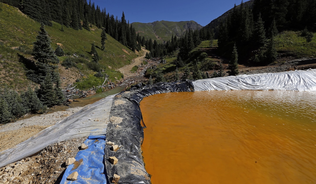 Water flows through a series of sediment retention ponds built to reduce heavy metal and chemical contaminants from the Gold King Mine wastewater accident, in the spillway about 1/4 mile downstream from the mine, outside Silverton, Colo., Friday, Aug. 14, 2015. Officials have said that federal contractors accidentally released more than 3 million gallons of wastewater laden with heavy metals last week at the Gold King Mine near Silverton. The pollution flowed downstream to New Mexico and Utah. (AP Photo/Brennan Linsley)