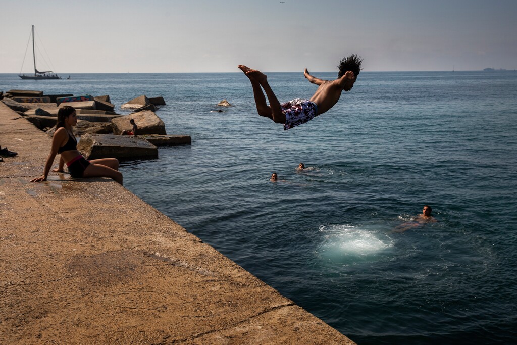 (Emilio Morenatti | AP file photo) A boy jumps into the water at the beach in Barcelona, Spain, on July 25, 2019. The U.S. National Oceanic and Atmospheric Administration said Thursday Aug. 15, 2019, that July was the hottest month measured on Earth since records began in 1880.