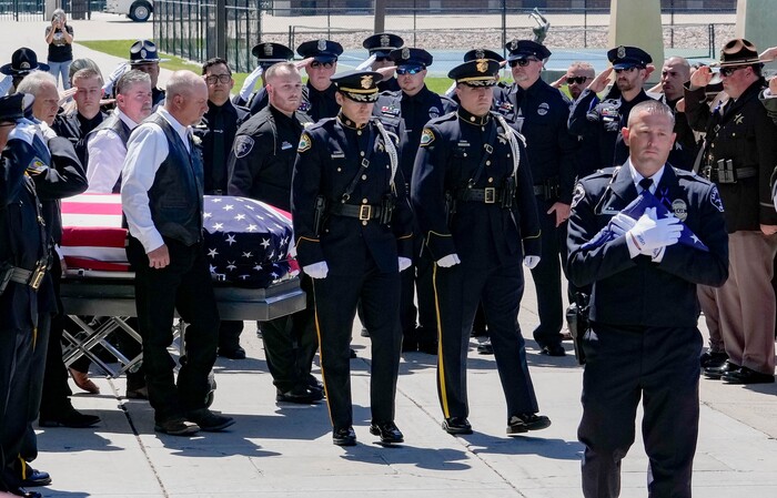 (Francisco Kjolseth  |  The Salt Lake Tribune) Santaquin police Lt. Mike Wall, right, walks ahead of pallbearers carrying the casket containing Santaquin police Sgt. Bill Hooser following services at the UCCU Center at Utah Valley University on Monday, May 13, 2024.