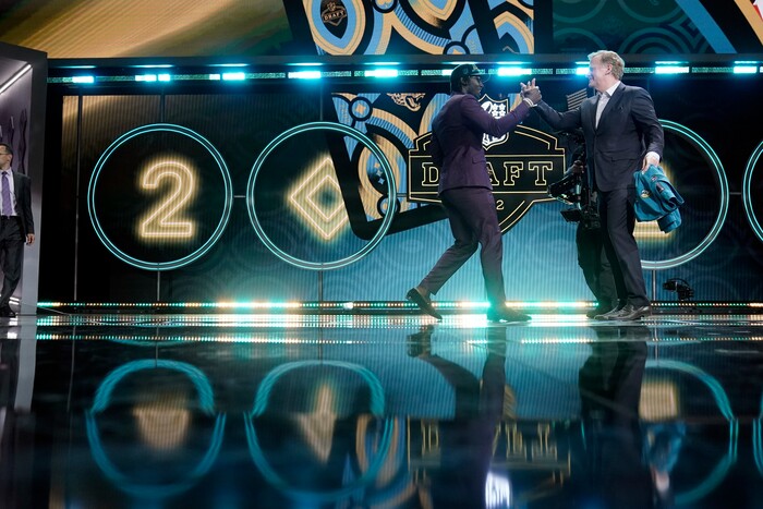 Utah linebacker Devin Lloyd shakes hands with NFL Commissioner Roger Goodell after being chosen by the Jacksonville Jaguars with the 27th pick of the NFL football draft Thursday, April 28, 2022, in Las Vegas. (AP Photo/Jae C. Hong)