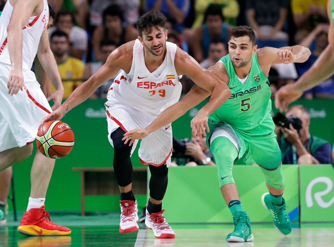 Spain's Ricky Rubio (79) is fouled by Brazil's Raulzinho Neto (5) during a basketball game at the 2016 Summer Olympics in Rio de Janeiro, Brazil, Tuesday, Aug. 9, 2016. (AP Photo/Charlie Neibergall)
